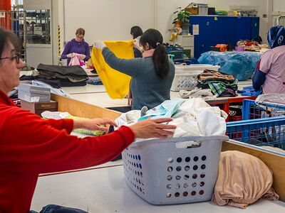 Eine Frau sortiert Textilspenden